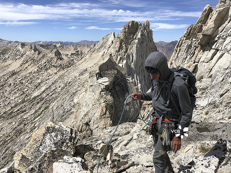 攀岩者和登山者：携带攀岩装备、背包和头盔，行走在布里奇波特加利福尼亚州附近马特峰下的锯齿岭上的花岗岩岩石上图片素材
