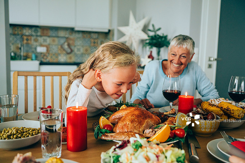 可爱的小女孩享受新鲜烤火鸡的香味图片素材
