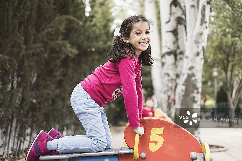 在游乐场玩具自行车上的小女孩图片素材
