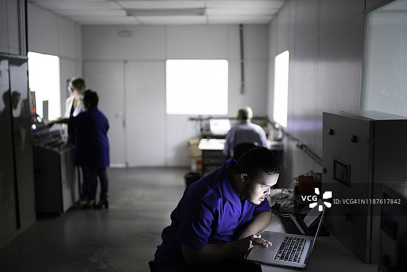 在工厂使用笔记本电脑的员工图片素材