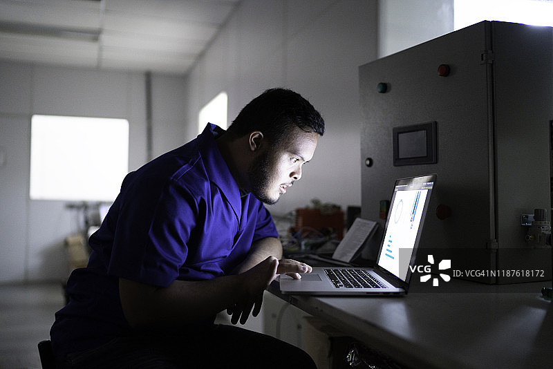 在工厂使用笔记本电脑的员工图片素材