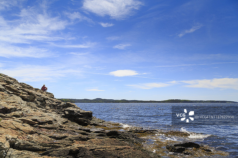 缅因州的礁石海岸，夏季有登山者休息图片素材
