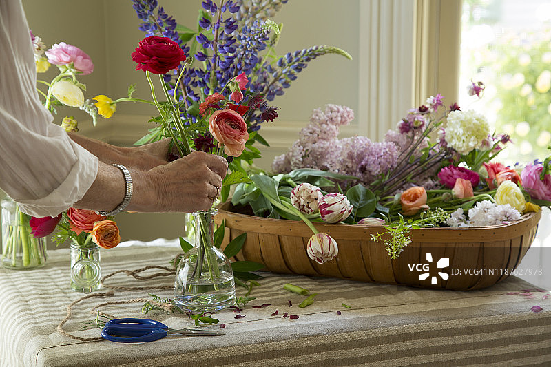 花店桌子上摆放的各种鲜花与花艺师图片素材