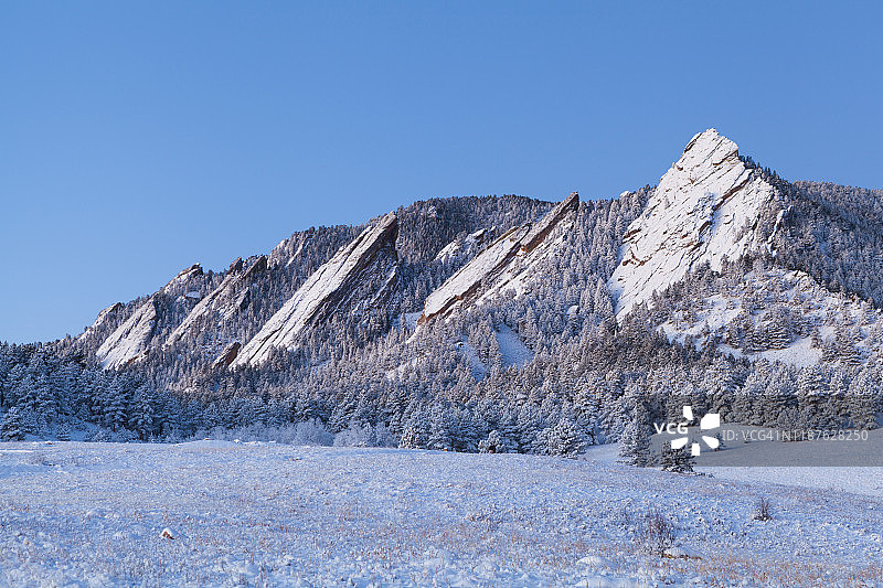 科罗拉多州博尔德市：雪中熨斗山和草地图片素材