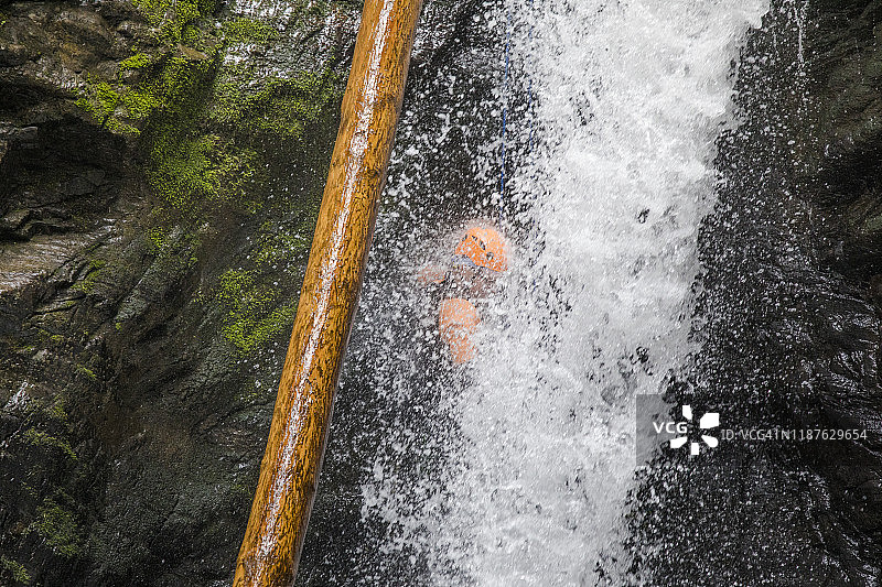 男人在加拿大不列颠哥伦比亚省的瀑布上绳降图片素材