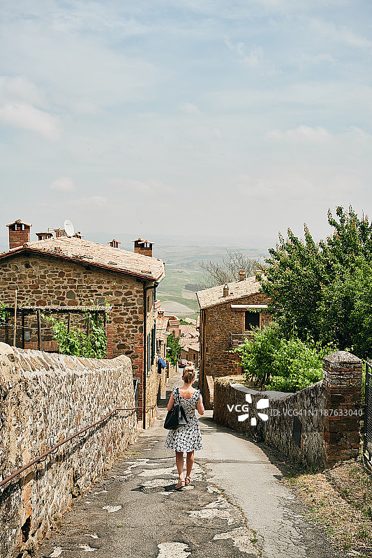 女人走在有老房子的街上图片素材