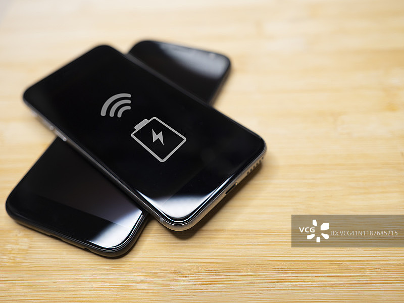 两部智能手机在木桌上共享充电图片素材