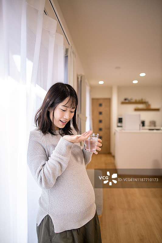 孕妇在客厅服药图片素材