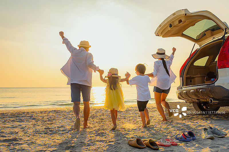 日落时分在海滩上漫步的家庭图片素材