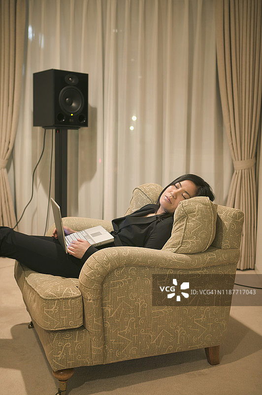 女人在东京的扶手椅上休息，手持笔记本电脑图片素材