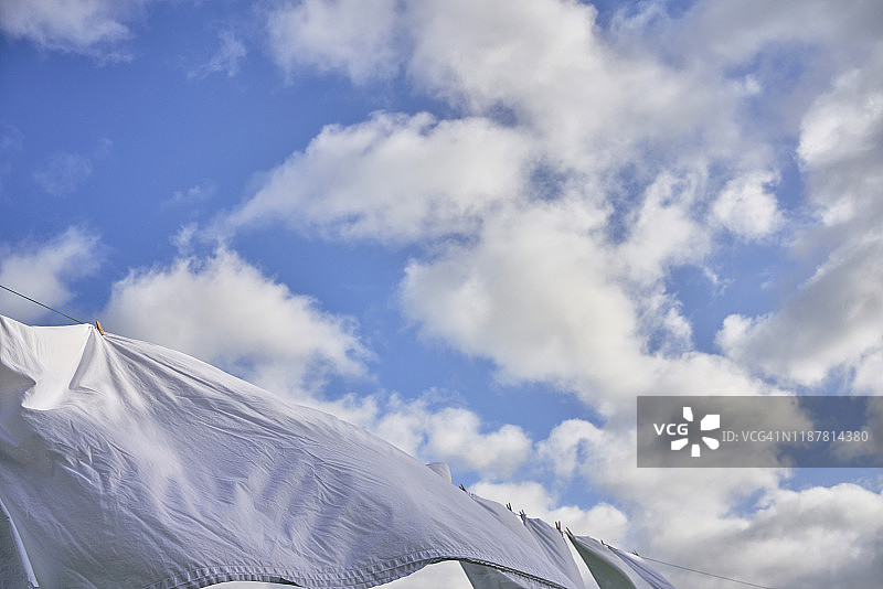 晾衣绳上随风飘扬的干净白色衣物图片素材