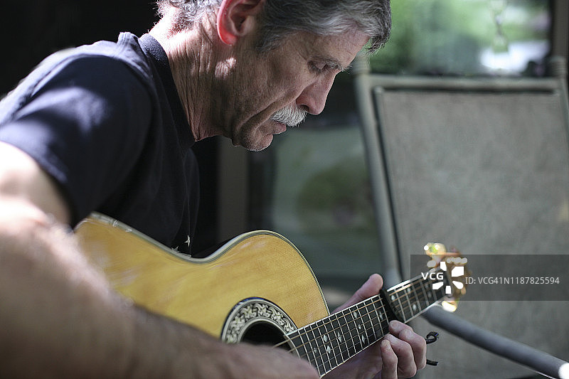 一位年长的男人在弹吉他图片素材