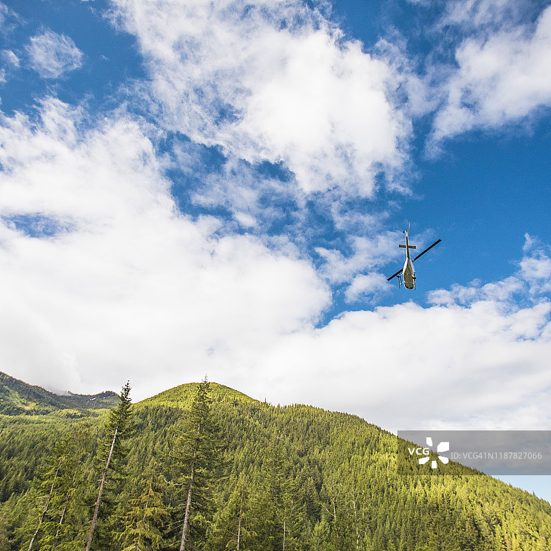 夏季在群山中飞行的直升机图片素材