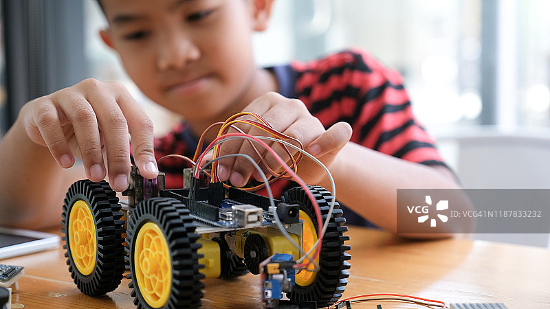 专注的男孩在实验室创造机器人图片素材