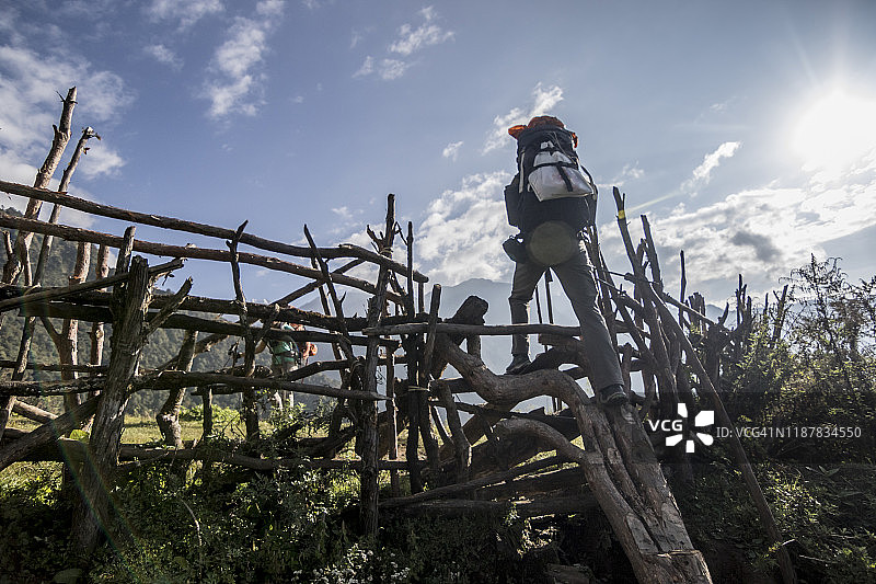 徒步旅行者穿越尼泊尔乡村的栅栏图片素材