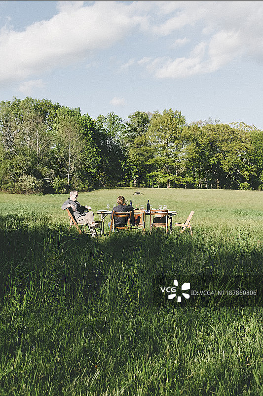 父子坐在田野的桌旁图片素材