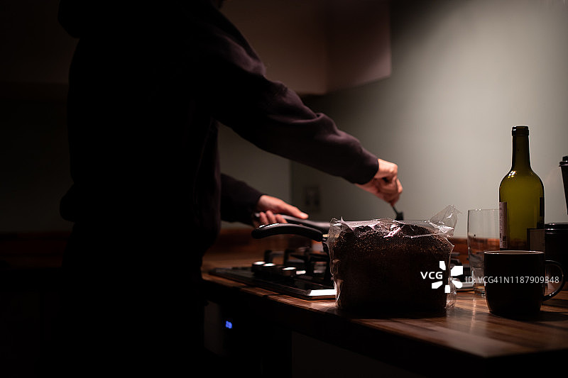 男子晚上在厨房做饭图片素材