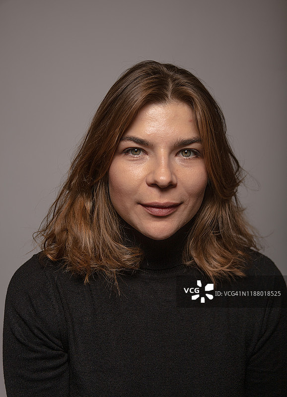 波浪棕发、面容平静的女子自然写真图片素材