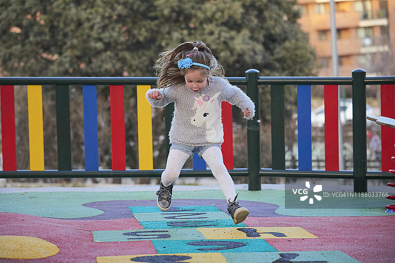 女孩在操场上玩跳房子游戏图片素材