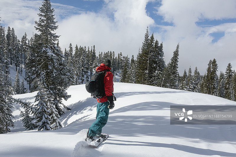 在沙斯塔山加利福尼亚州人迹罕至的森林地形上，背着背包滑雪的健壮滑雪者图片素材