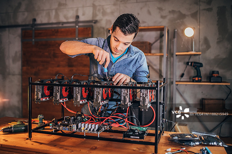年轻男人制作比特币挖矿机图片素材