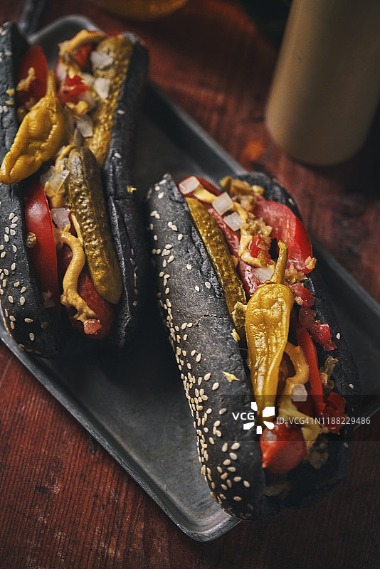 黑面包辣椒热狗配甜椒、番茄、泡菜和调味品图片素材