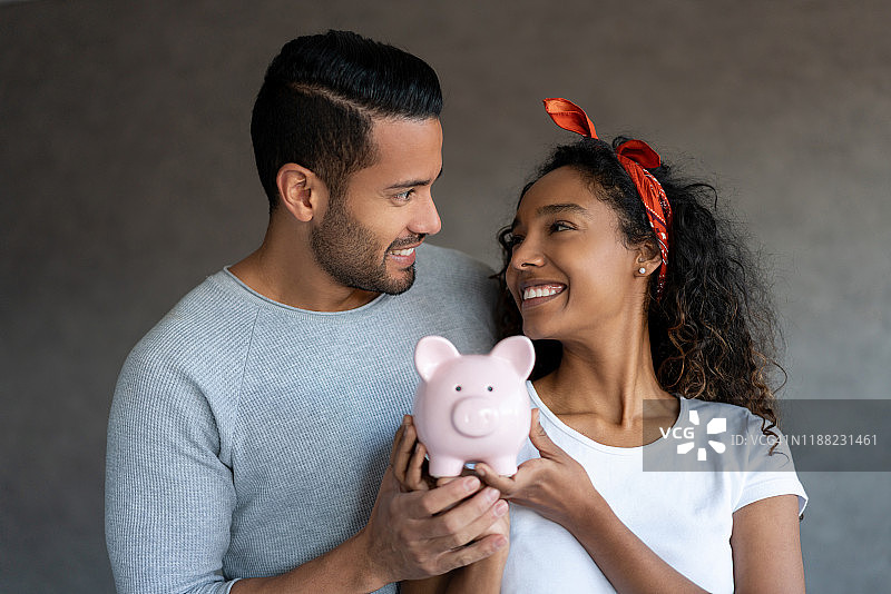 在家用存钱罐攒钱的幸福夫妇图片素材