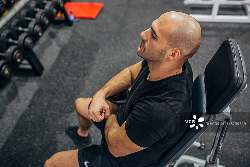 用哑铃锻炼的健壮男运动员图片素材