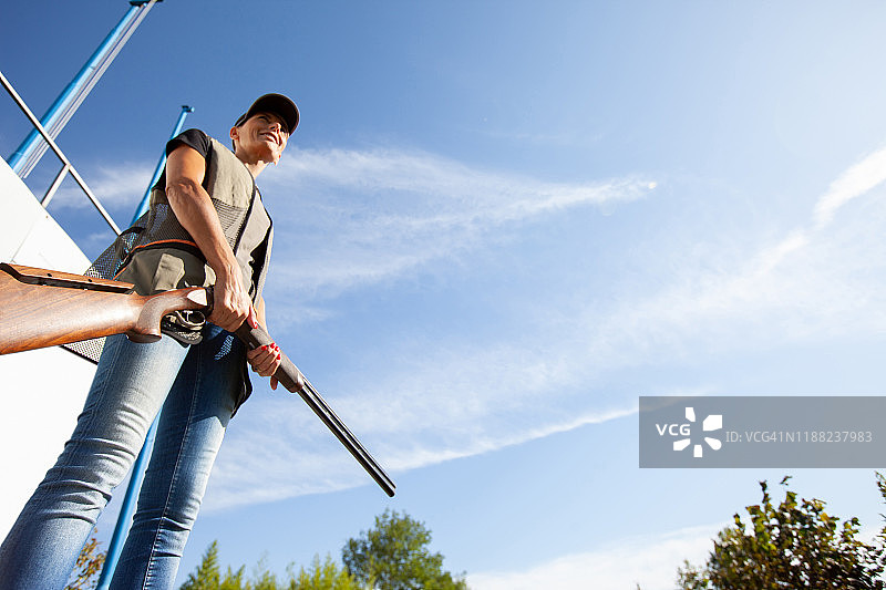 中年女人在领奖台上持猎枪的仰视照片图片素材