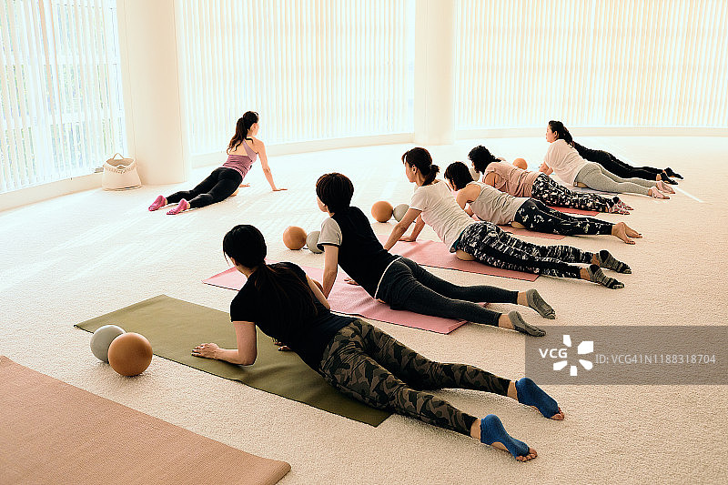 女教练在健身工作室带领普拉提课堂图片素材