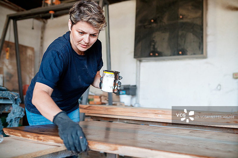 专注的木匠涂清漆图片素材