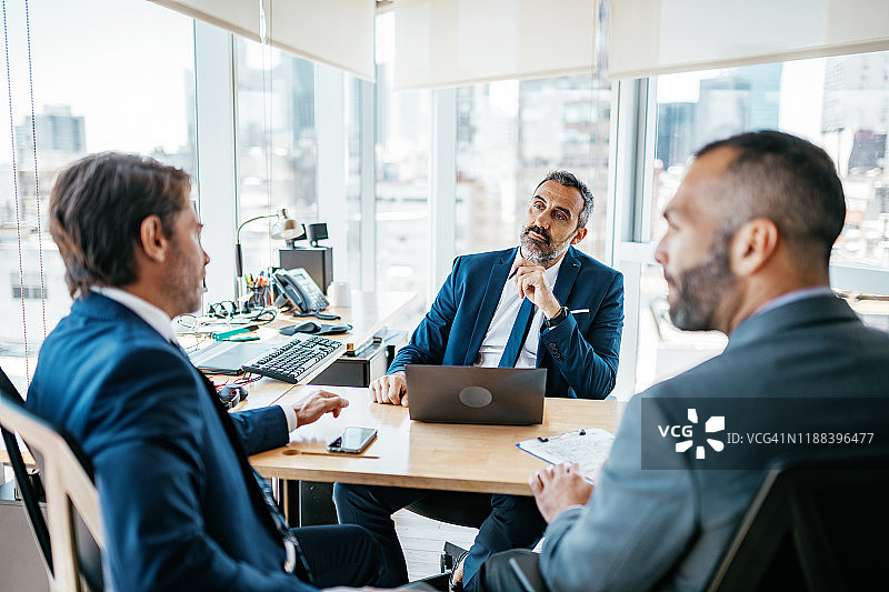 办公室里，经理与顾问决策中的中年商人图片素材