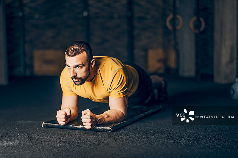 健壮的男人在健身房锻炼前做热身平板支撑图片素材