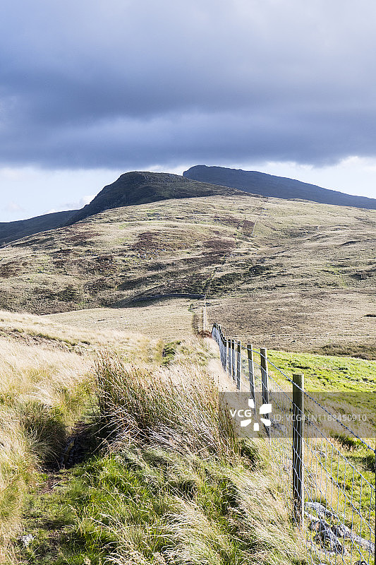 从山上眺望带有栅栏的山顶；在通往阿兰福德威山顶的人行道上行走，斯诺多尼亚，威尔士。九月图片素材