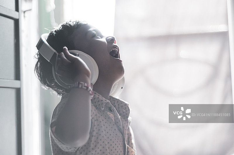 小男孩戴耳机听音乐图片素材