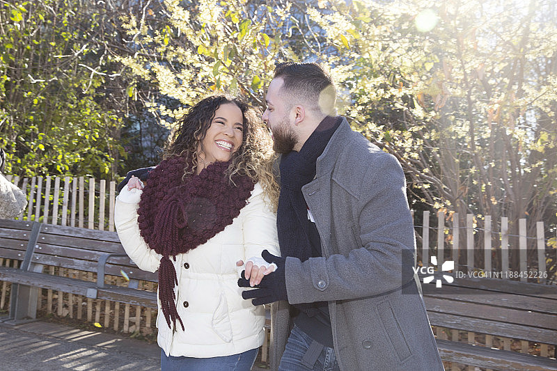 一对千禧一代的拉丁裔情侣在秋日温暖的阳光下于公园里快乐地跳舞图片素材
