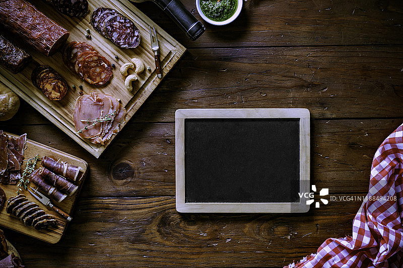 各种腌制火腿腿和奶酪美味开胃菜在乡村木桌上，框架中有复制空间图片素材