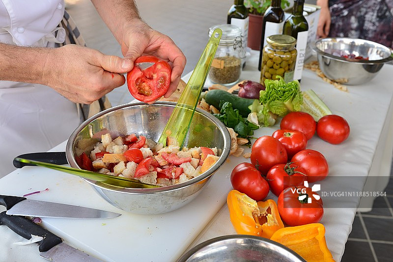 白人厨师使用削皮刀制作西红柿面包豆沙拉图片素材