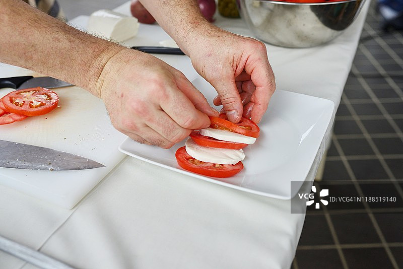 年长的白人厨师，番茄沙拉，食物展示图片素材