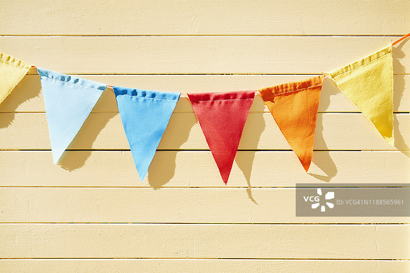 彩色三角旗/串旗，夏季黄色木墙派对装饰图片素材