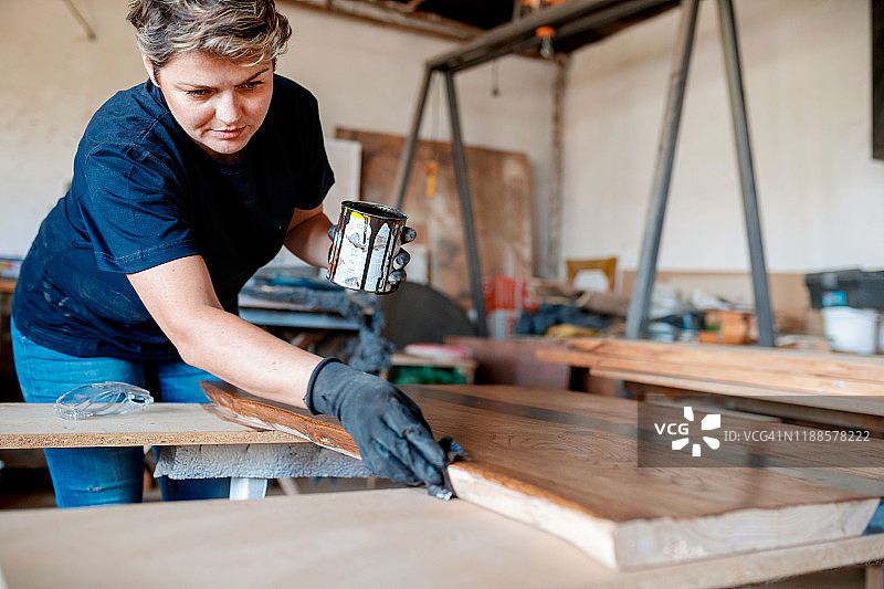 木匠戴防护手套涂清漆图片素材