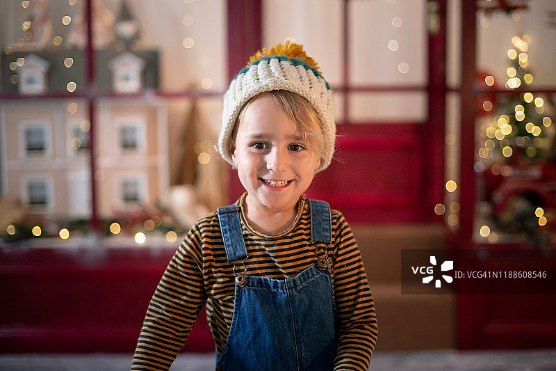 男孩站在圣诞节的商店前图片素材