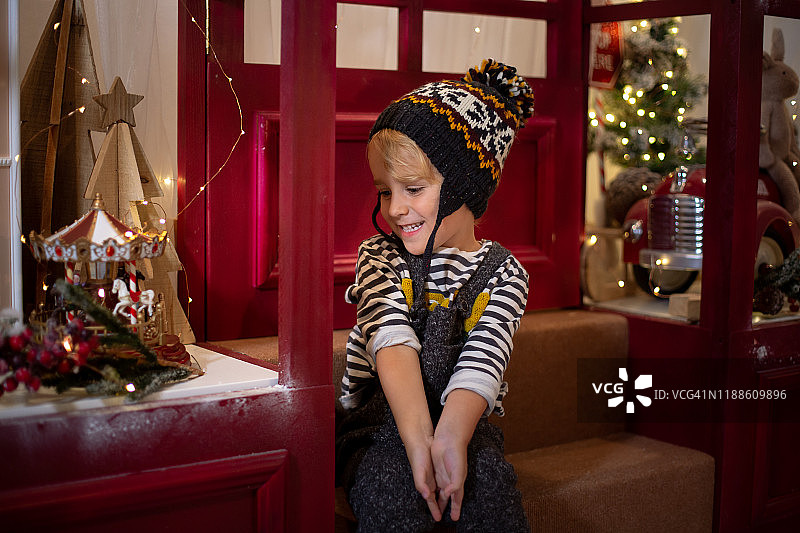 男孩看着圣诞玩具店的橱窗图片素材