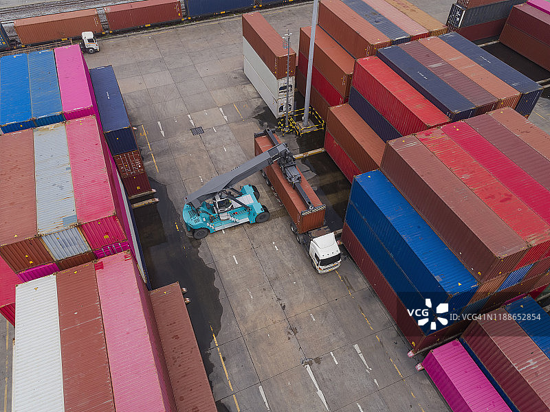 叉车在仓库中将集装箱装载到卡车上，用于物流运输、进出口图片素材