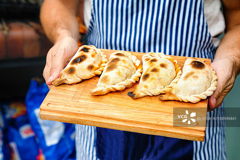 烘焙师手中案板上的图库曼馅饼特写图片素材