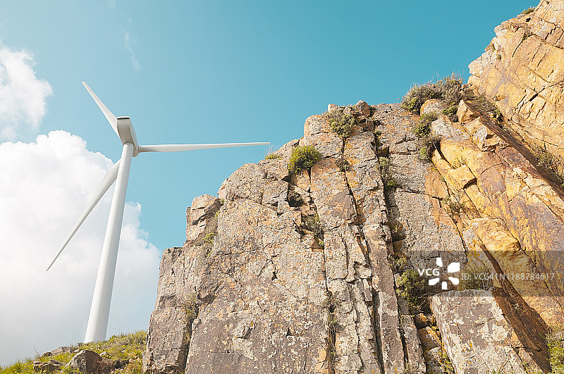 岩石悬崖和风力发电的仰视角度图片素材