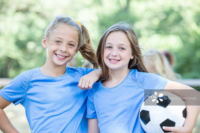 足球运动员抱着足球一起微笑图片素材