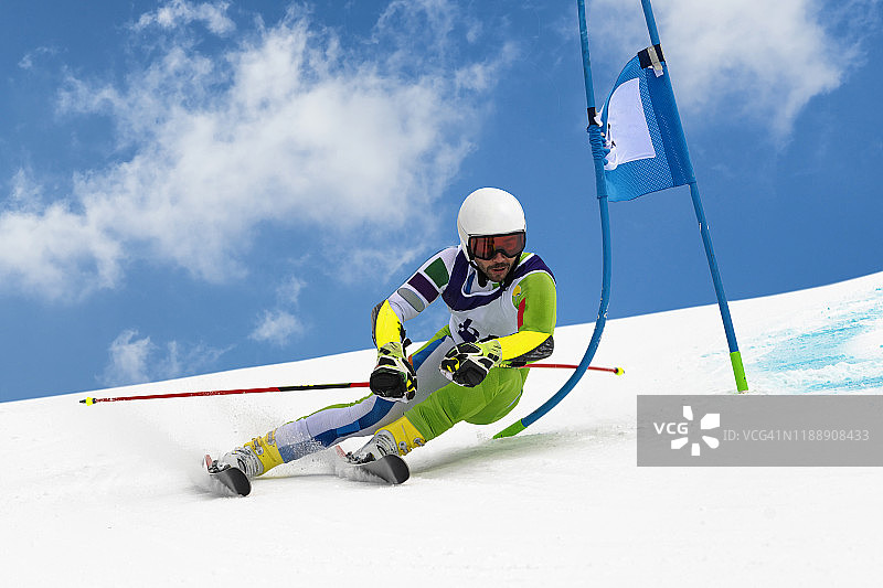 在蓝天下进行大回转练习的年轻高山滑雪者图片素材