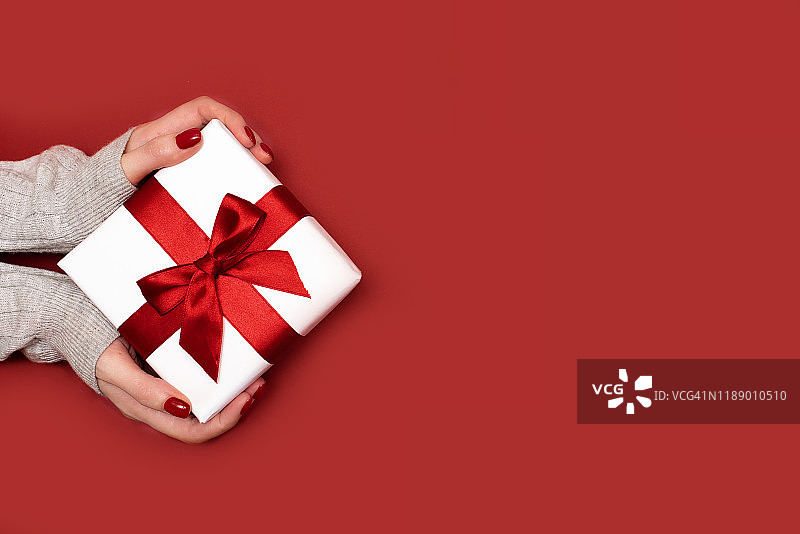 礼物在女性手中的彩色背景俯视图。图片素材