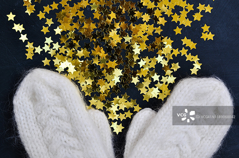 圣诞节舒适背景，白色针织手套和金色星星图片素材